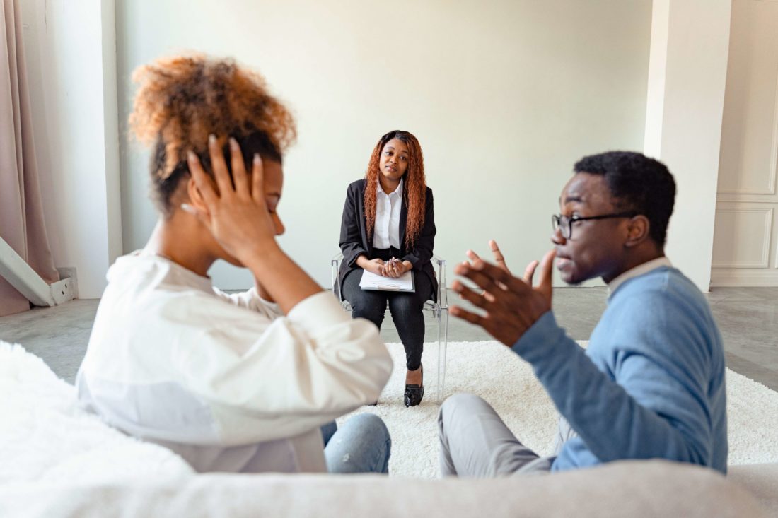 A black couple arguing during a therapy session