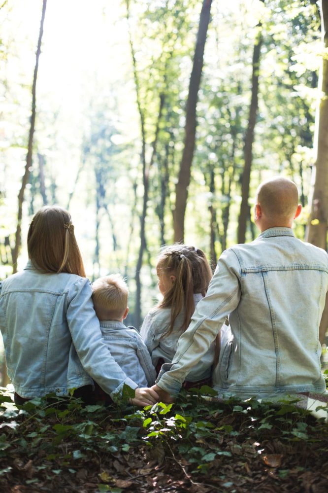 A family of four sitting outside looking away from the camera