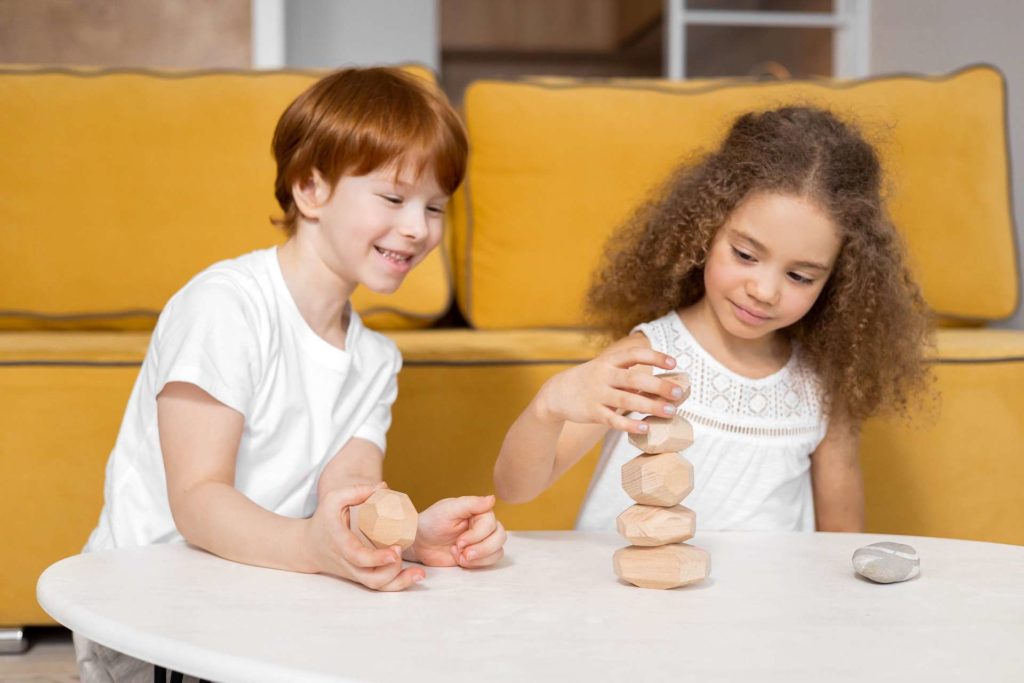 A red-haired boy and mixed race girl playing with rocks on a table