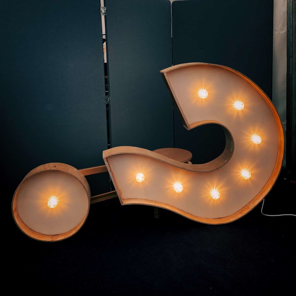 A light-up question mark made of metal on the floor