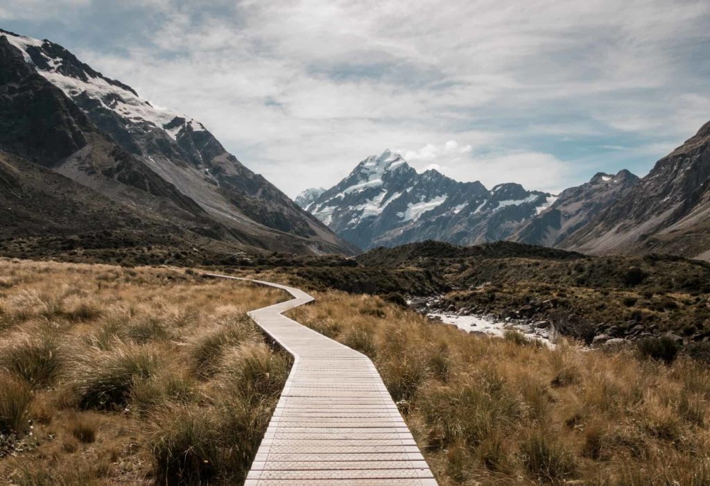 A wooden path at the base of mountains