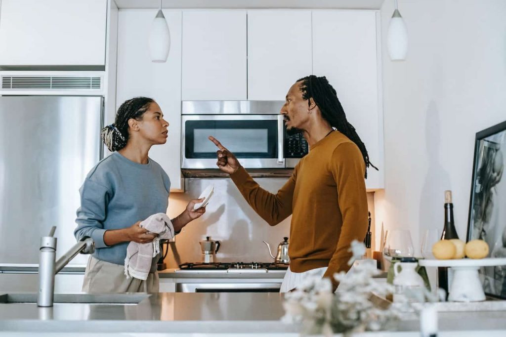 Black man and woman aruging in a kitchen