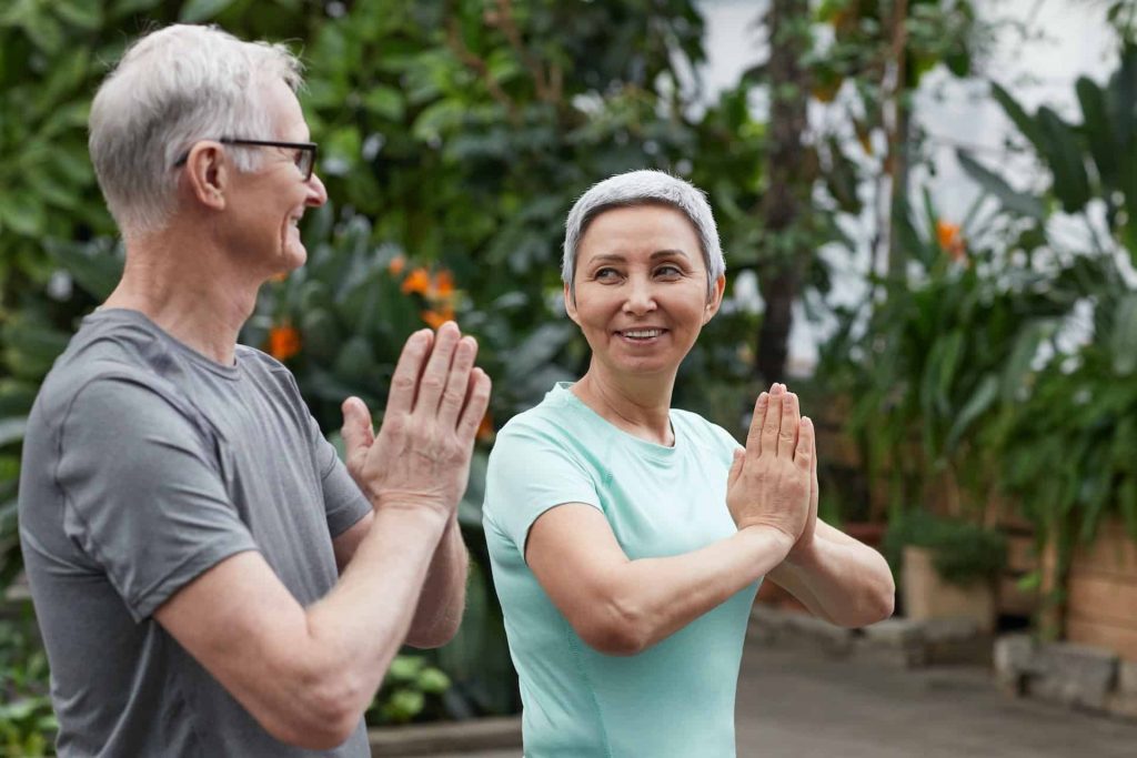 Senior citizen couple practicing yoga together