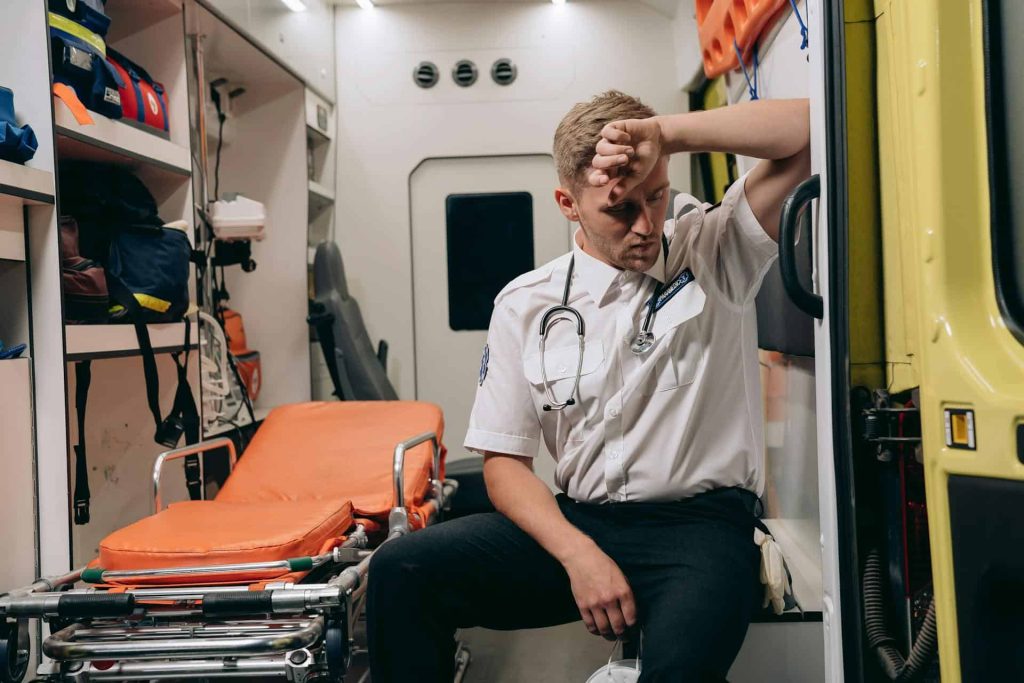 A depressed first responder sitting in the back on an ambulance